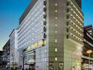 un grand bâtiment situé dans une rue de la ville la nuit dans l'établissement Hotel Plumm, à Yokohama