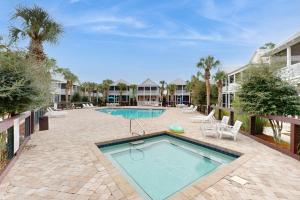 a swimming pool in a patio with chairs and a swimming pool at Barefoot Cottages #B32 in Highland View