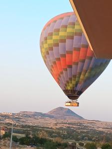 Un globo aerostático colorido volando en el cielo en İclal villa cappadocia, en Uchisar