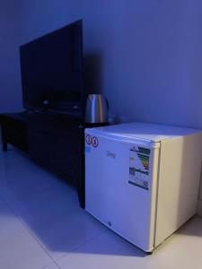 a small refrigerator with a tv on top of it at قرطبه مودرن - قريبة من المطار in Riyadh