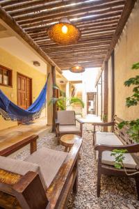 a porch with benches and a hammock in a house at Pousada Sunbrazil in Jericoacoara