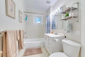 a white bathroom with a toilet and a tub and a sink at Walk to Lake Michigan Pet-Friendly Charlevoix Gem in Charlevoix +20 photos