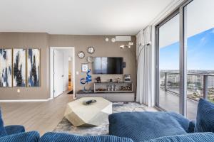 a living room with a blue couch and a large window at Hyde Beach House - 2BD-2BA MANSION WITH DIRECT OCEAN VIEW, Resort Amenities, Rooftop Pool and Hot tub, Tennis court, few min walk to the ocean in Hollywood +59 photos