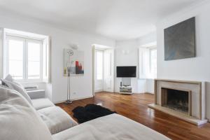 a living room with a couch and a fireplace at Baixa Chiado LUXURY BEDROOMS in Lisbon