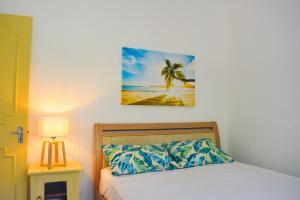 a bedroom with a bed and a picture of a beach at Sands Beach Villa Flic en Flac in Flic-en-Flac