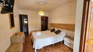 a bedroom with a white bed in a room at Complejo turistico el Merendero in Finisterre