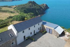 an aerial view of a white building next to the water at Maison vue exceptionnelle mer sur les falaises de Plouha, Côtes d'Armor in Plouha