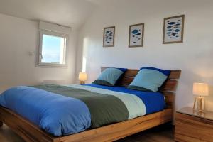 プルーアにあるMaison vue exceptionnelle mer sur les falaises de Plouha, Côtes d'Armorの青い枕が付いた大きなベッドのある寝室
