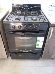 a black stove in a kitchen with a counter at Los Poin 2 in Mar de Cobo
