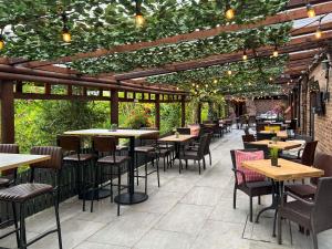 a restaurant with tables and chairs under a pergola at Enlighten Lodge Great Ayton Yorkshire in Great Ayton