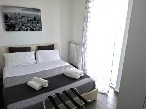 a bedroom with a bed with two chairs and a window at Airport Bari palese LUXURY 2 in Bari