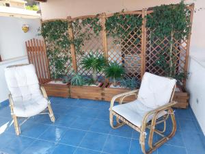 two chairs sitting on a patio with plants at B&B La Filanda in Scilla