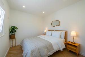 una camera da letto con un letto con lenzuola e cuscini bianchi di Sintra premium Villa a Sintra