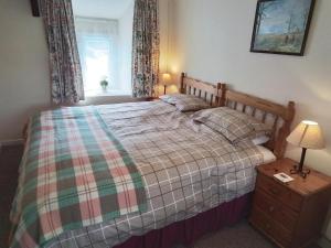 - une chambre avec un grand lit et une couverture tressée dans l'établissement Dairy Cottage Newcastle Emlyn, à Newcastle Emlyn
