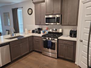 a kitchen with stainless steel appliances and wooden cabinets at Ts3 Houston in Missouri City