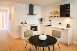 a kitchen with a table and chairs in a kitchen at Vita Home Lanzarote I Deluxe Apartments in Arrecife