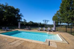 ein Swimmingpool mit Stühlen und Sonnenschirmen in der Unterkunft Le Grand Pech in Le Sirey