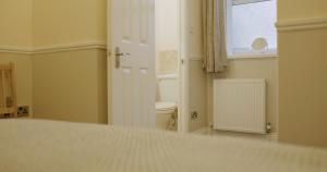 a bathroom with a toilet and a window at Free Parking, Entire 8 Ensuite Bedroom Townhouse, Fully Equipped Kitchen, Dining Room & Lounge, Perfect for Family Gatherings, Long Term Contractor, Relocation, etc Stays, 15 mins to Nissan, 20 mins to Sunderland & Newcastle, See our Site for Assurance in South Shields +37 photos