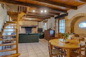 ein Wohnzimmer mit einer hölzernen Wendeltreppe und einem Tisch in der Unterkunft Le Grand Pech in Le Sirey
