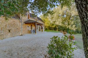 eine Außenansicht eines Steinhauses mit Auffahrt in der Unterkunft Le Grand Pech in Le Sirey