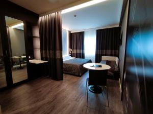 a hotel room with a bed and a small table at The Sydney Hotel in Bologna