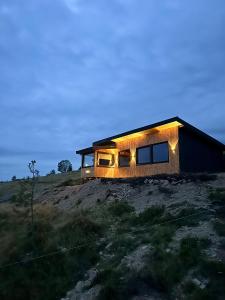 a house on a hill with lights on it at Cabană Vinkiș in Măguri-Răcătău +6 photos