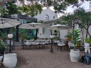 an outdoor patio with tables and chairs and umbrellas at concierge hotel in Durban