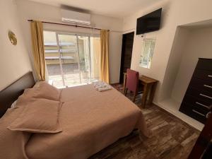 a bedroom with a bed and a desk and a window at Complejo Roccatini in Villa Carlos Paz +53 photos