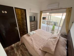 a bedroom with a bed and a sliding glass door at Complejo Roccatini in Villa Carlos Paz