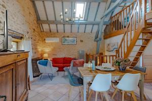 Una sala de estar con una mesa y sillas y un sofá rojo. en La Gourmandise d'Huguette, en Beynac-et-Cazenac