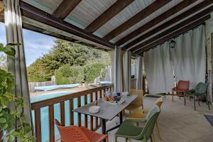 Un patio con una mesa y sillas en un balcón. en La Gourmandise d'Huguette, en Beynac-et-Cazenac