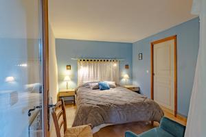 Un dormitorio con una cama grande con paredes azules. en La Gourmandise d'Huguette, en Beynac-et-Cazenac 18 fotos más