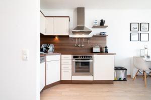 a kitchen with white cabinets and a stove top oven at Panoramic App A06-6 in Sierksdorf