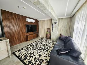 SPOT · Cobertura c/hidro em Aguas Claras, SPOT Apartments في برازيليا: غرفة معيشة مع أريكة وتلفزيون بشاشة مسطحة