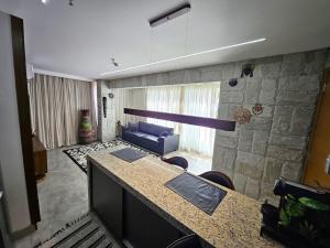 SPOT · Cobertura c/hidro em Aguas Claras, SPOT Apartments في برازيليا: غرفة معيشة مع أريكة زرقاء وجدار حجري