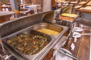 a buffet with many different types of food in trays at Hotel Saint George in Puerto Iguazú