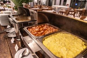 a buffet line with some food in trays at Hotel Saint George in Puerto Iguazú