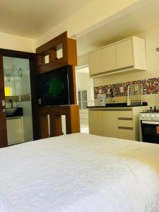 cocina con cama blanca en una habitación en Residencial De Aluguel, en Bombinhas