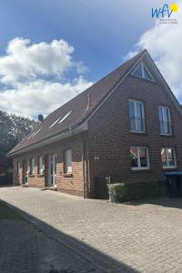 a brick house on a cobblestone street at Huus 24 in Borkum