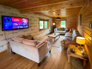 a living room with couches and a flat screen tv at Freedom Lodge Great Ayton Yorkshire in Great Ayton