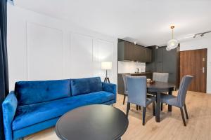 a living room with a blue couch and a table at Lumina I Comfy Apartments with Balcony I Parking I Pasaż Łódzki in Łódź