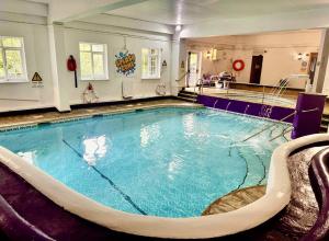 a large swimming pool in a hotel room at 2 Bed Lodge - Sleeps 4 - Pets - Pool - Garden in Penzance