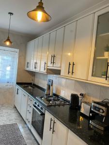 a kitchen with white cabinets and black counter tops at Casa Mirra in Cee