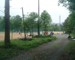 um parque com um banco ao lado de uma estrada de terra em Mizubaso em Gujo