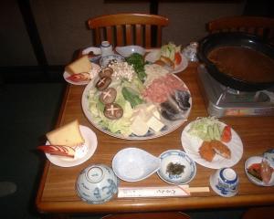 een houten tafel met een bord eten erop bij Mizubaso in Gujo