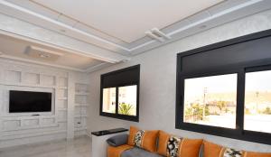 a living room with a couch and two windows at Appartement Riyam in Al Hoceïma