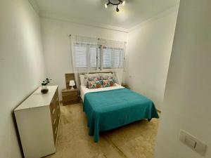 a small bedroom with a bed and a window at Deluxe Ciudad Jardin - by Gestión Vacacional Canarias in Las Palmas de Gran Canaria