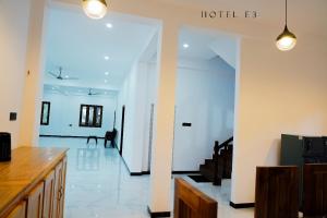 ein Wohnzimmer mit weißen Wänden und einem Flur mit Treppe in der Unterkunft Hotel E3 in Mannar