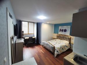 Un dormitorio con una cama y un escritorio con una silla. en STUDIO Beaulieu, en Cesson-Sévigné