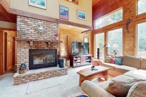 a living room with a stone fireplace and a tv at Suntec Getaway in Dover